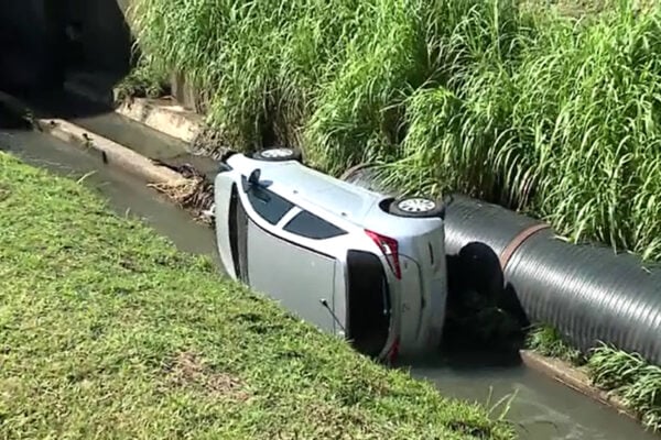  Carro cai dentro de canal após motorista se perder em curva